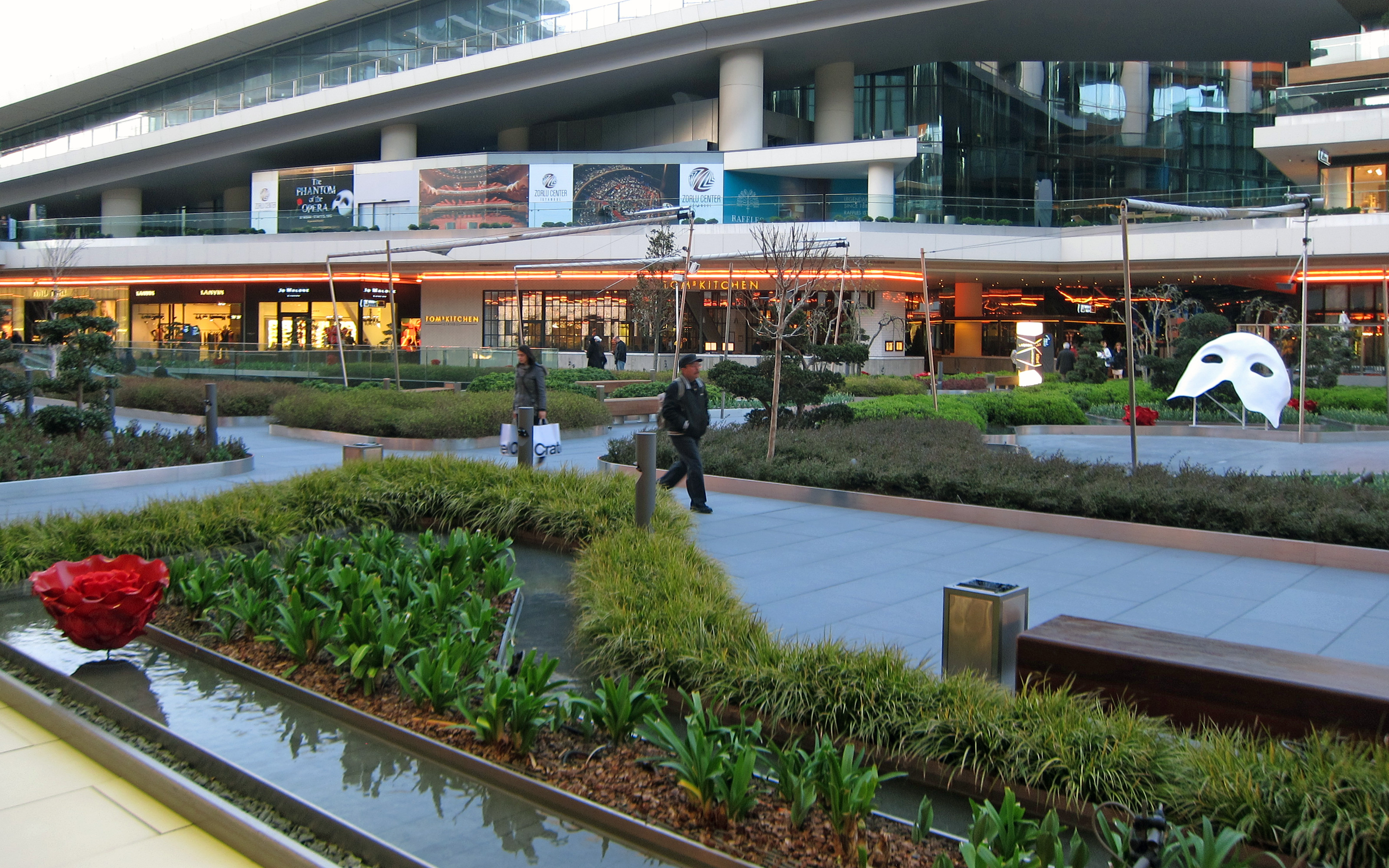 Centro comercial con áreas verdes y piscinas de agua