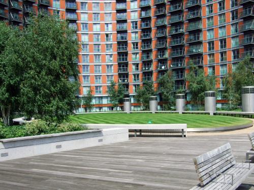Cubierta verde con césped y bancos en una terraza de madera